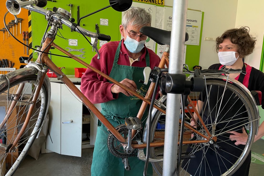 Un bénévole et une adhérente du Maillon Solidaire réparent un vélo
